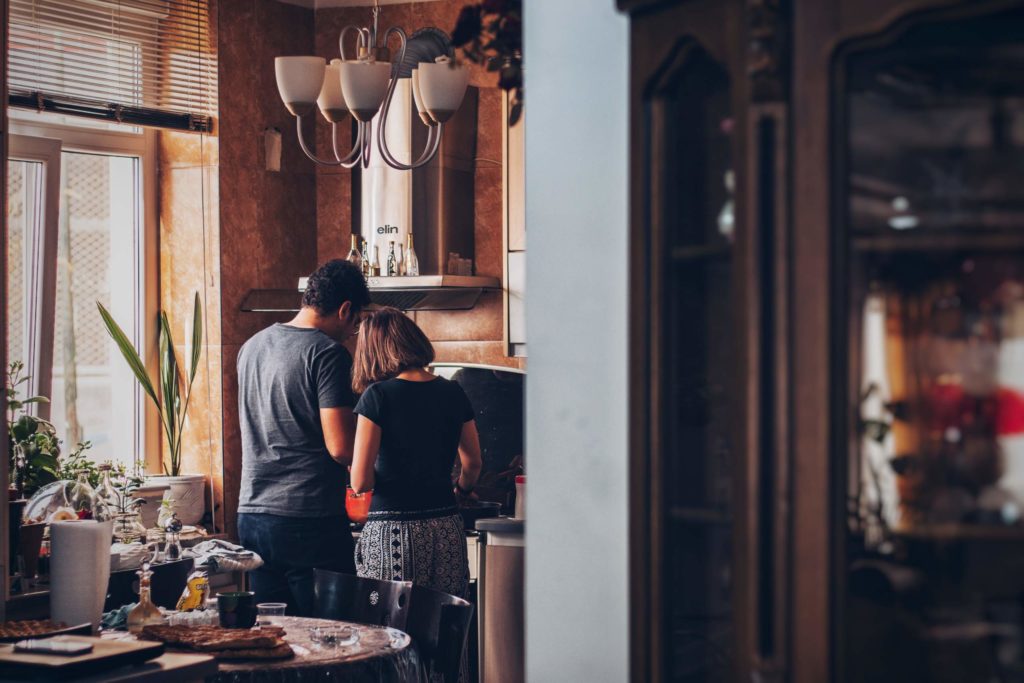 couple cooking together in kitchen with their backs turned