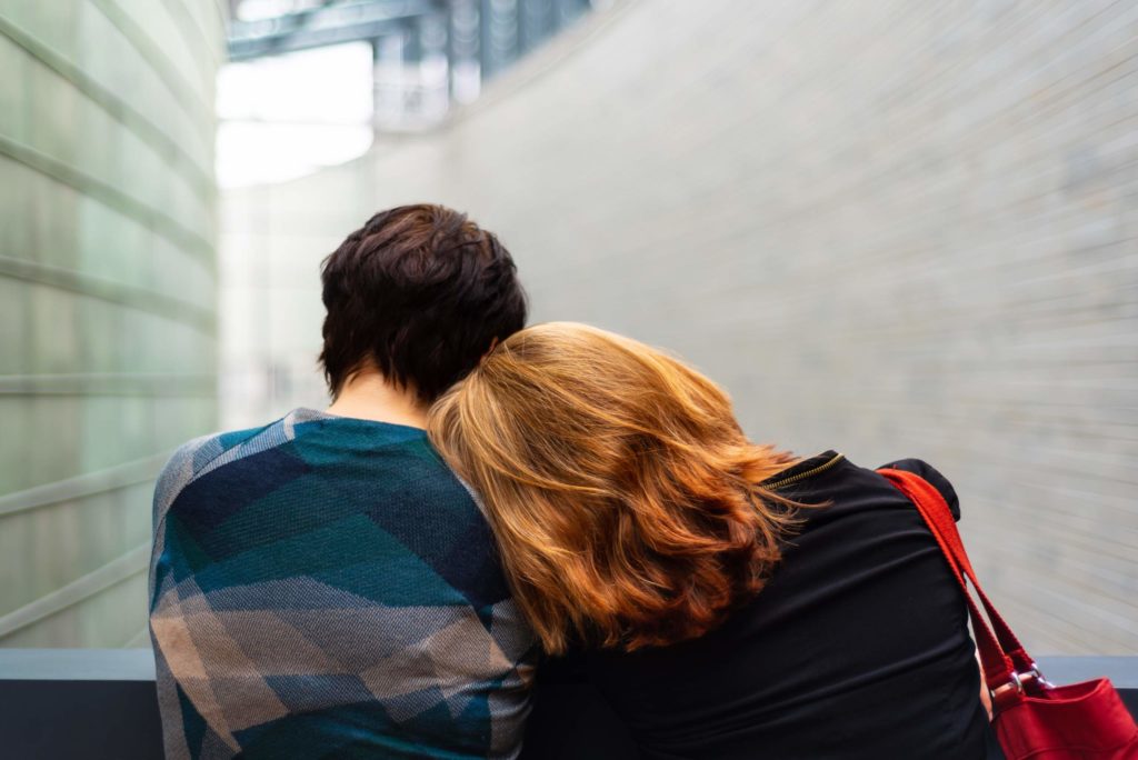 Young couple leaning on and comforting each other