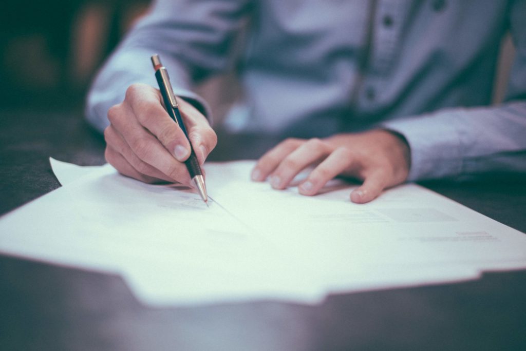 man in business shirt signing contract