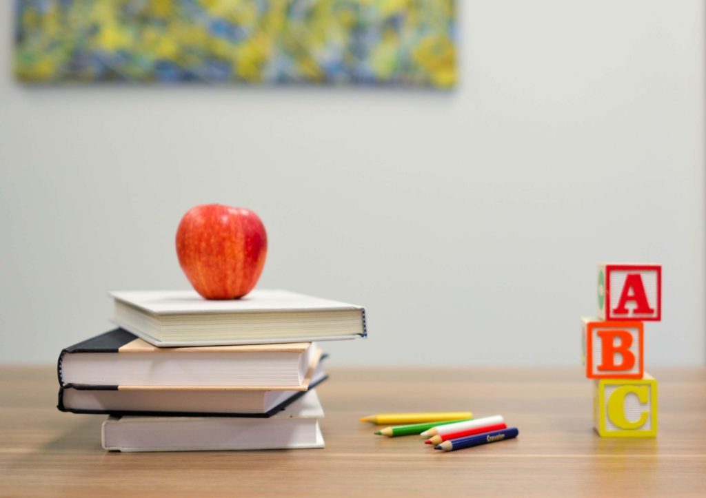 Red apple on top of school books