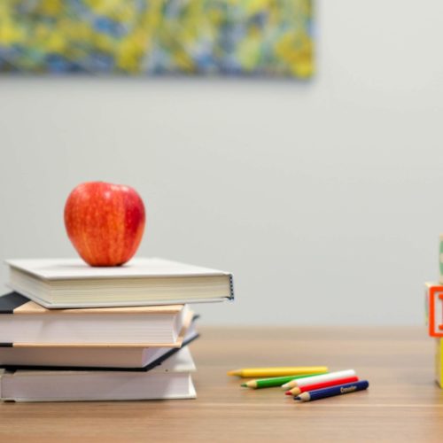 Red apple on top of school books