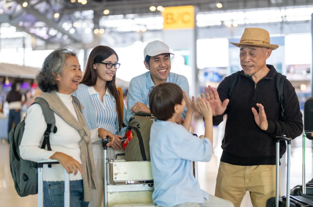 family of 5 waiting in the airport with their luggage about to go on holiday