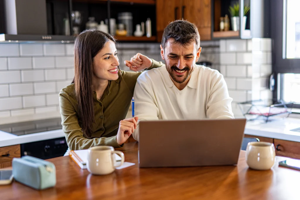 couple applying for a personal loan for a holiday together on a laptop