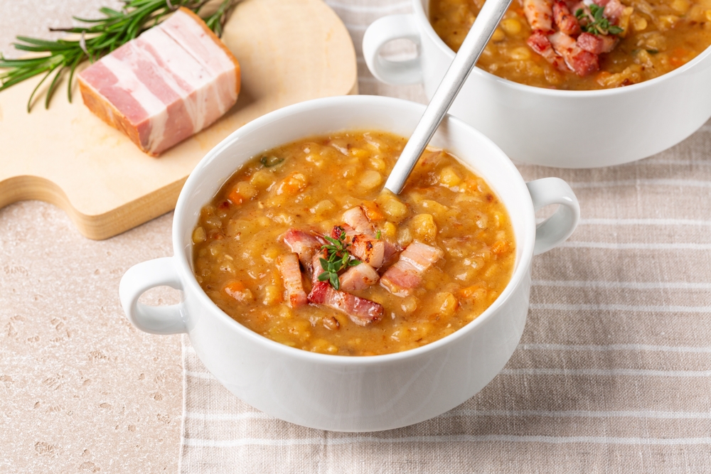 A delicioous pea and ham soup bowl, topped with fresh bacon bits ready to be served.