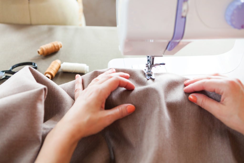 clothing being repaired on sewing machine - swoosh finance