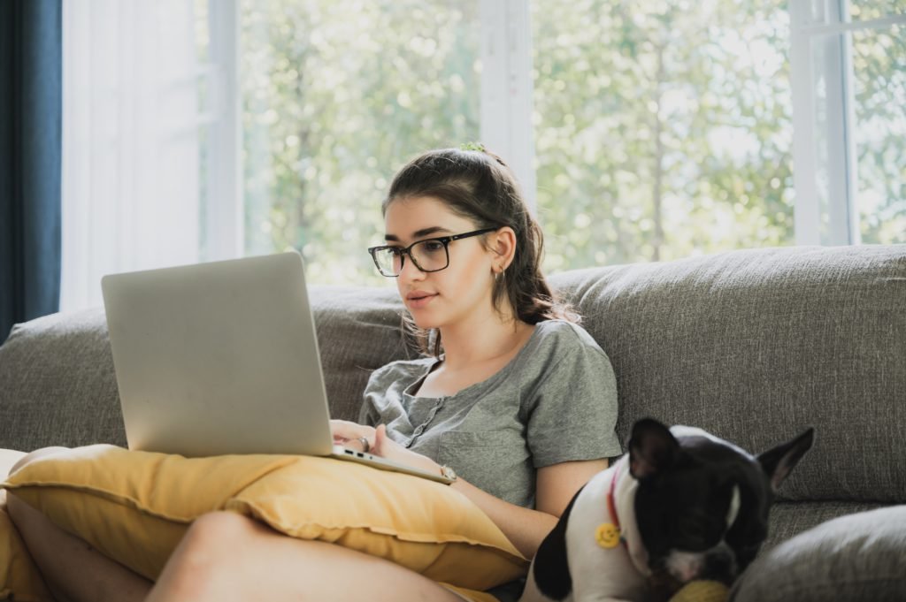 Woman on computer reading about possible negative affects of a personal loan on your credit score | Swoosh Finance