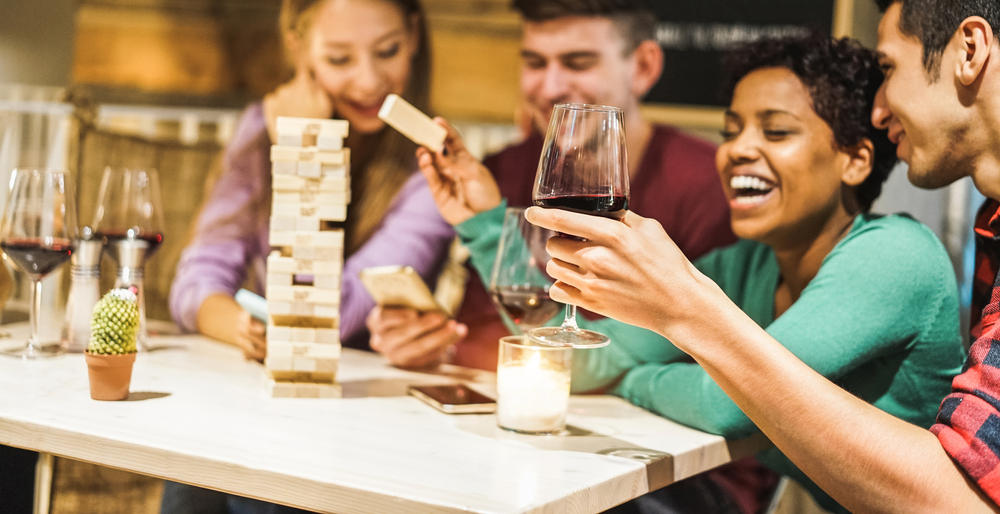 Two couples playing jenga at one of their homes.