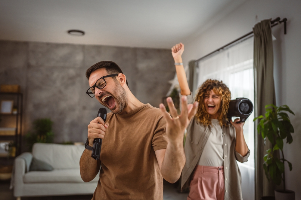 A couple at home singing karaoke into fake microphones.