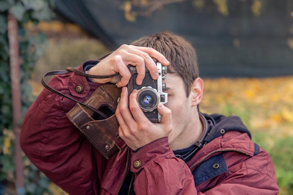 A man using an old fashioned camera to take a photo