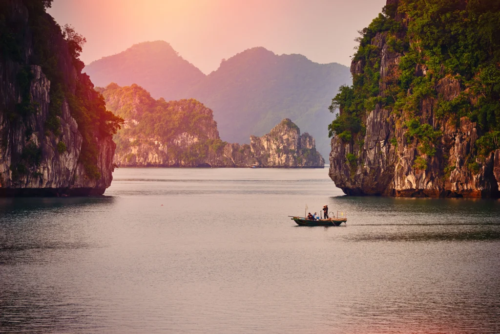 Single boat in large river between mountain cliffs in Vietnam