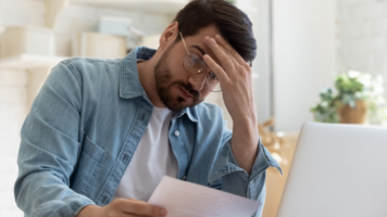 Worried man looking at his bills | Swoosh Finanace