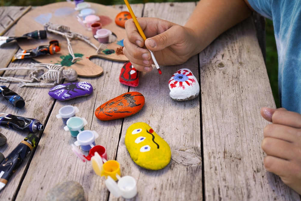 Kids painting rocks to make them look like halloween monsters