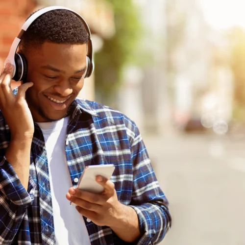 how do payday loans work; young man holding phone and listening to music | Swoosh Finance