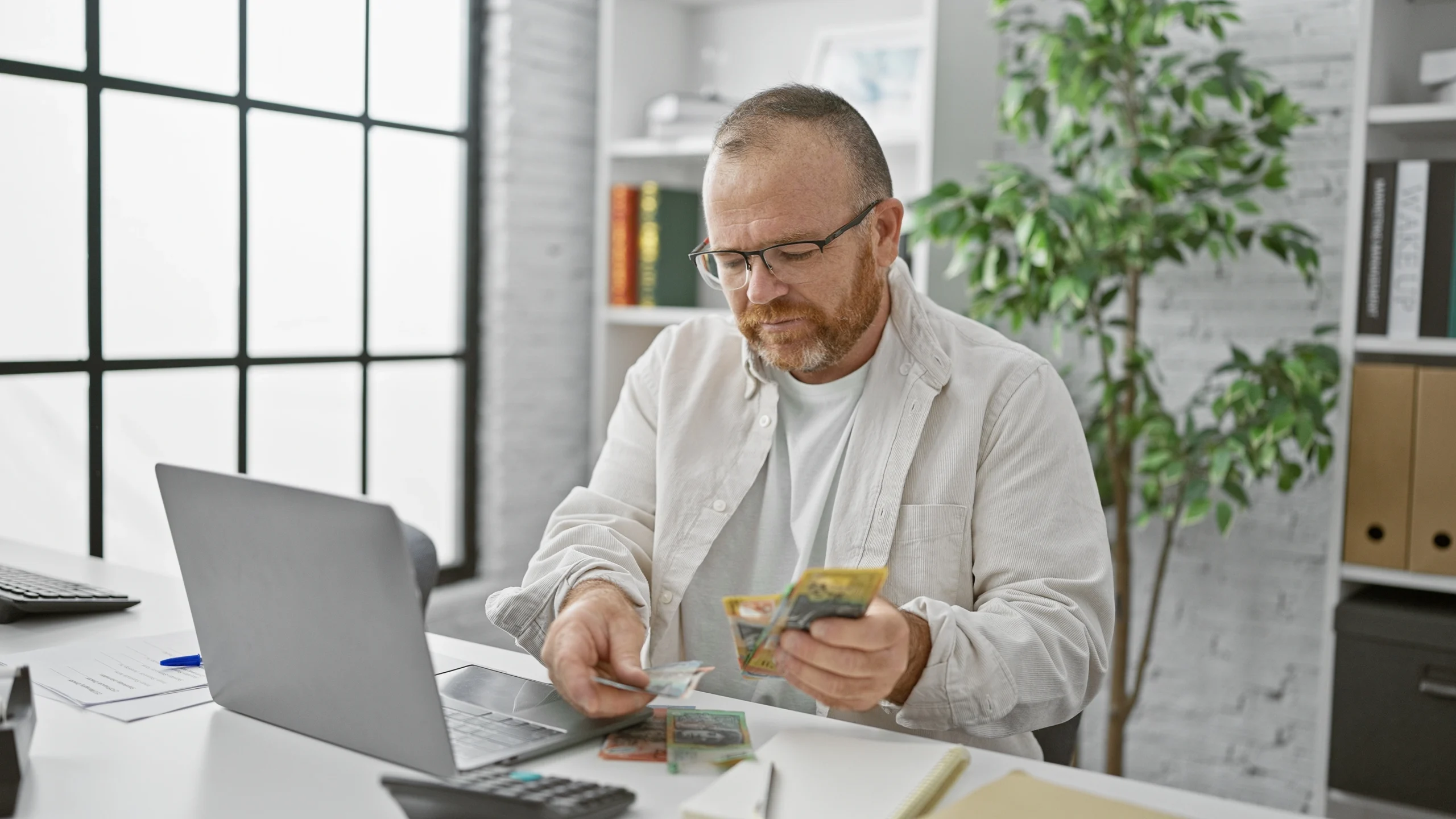 A man counts out the cash he got in his last tax refund as he plans to pay off his small Swoosh Finance loan