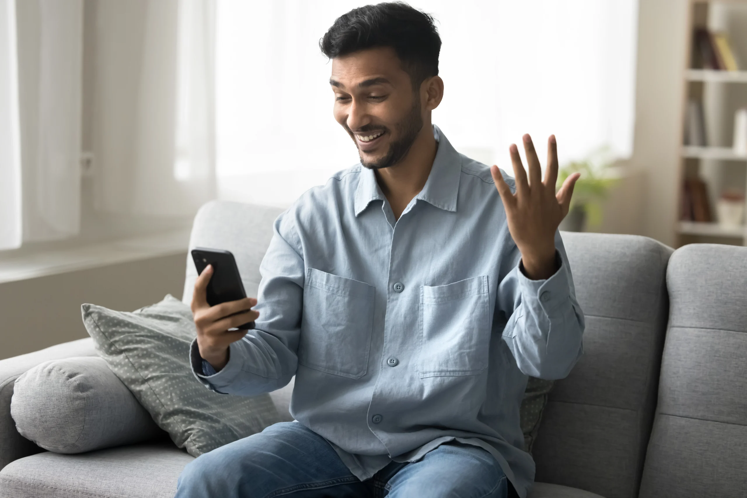 Excited man smiles at his phone after getting an urgent loan