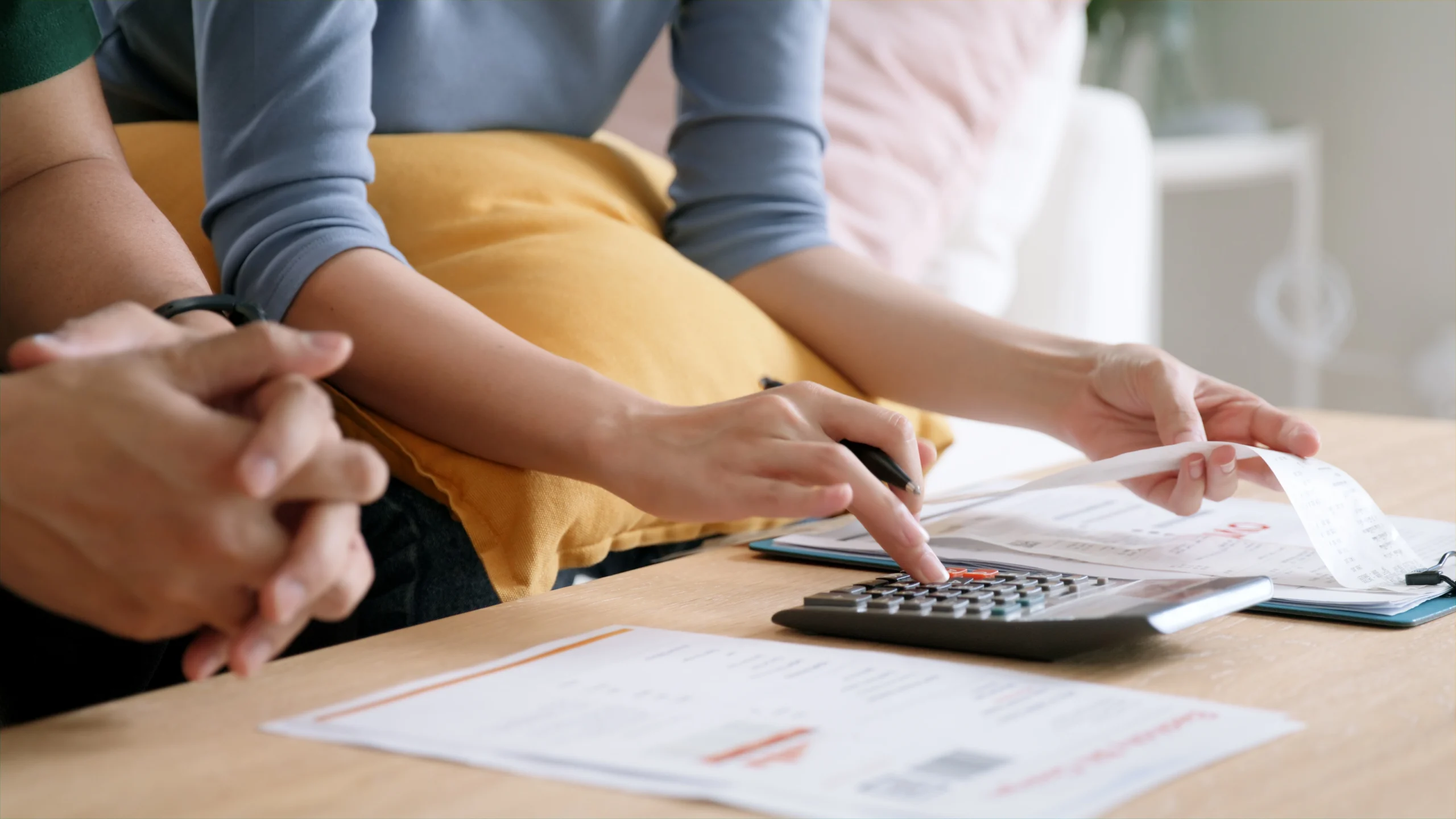 Close up of a couple adding up receipts to create a budget and save money