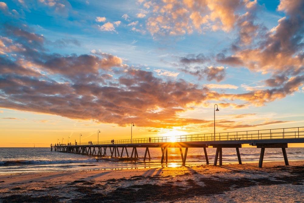 Glenelg Beach at sunset with people on pier as a free thing to do in Adelaide