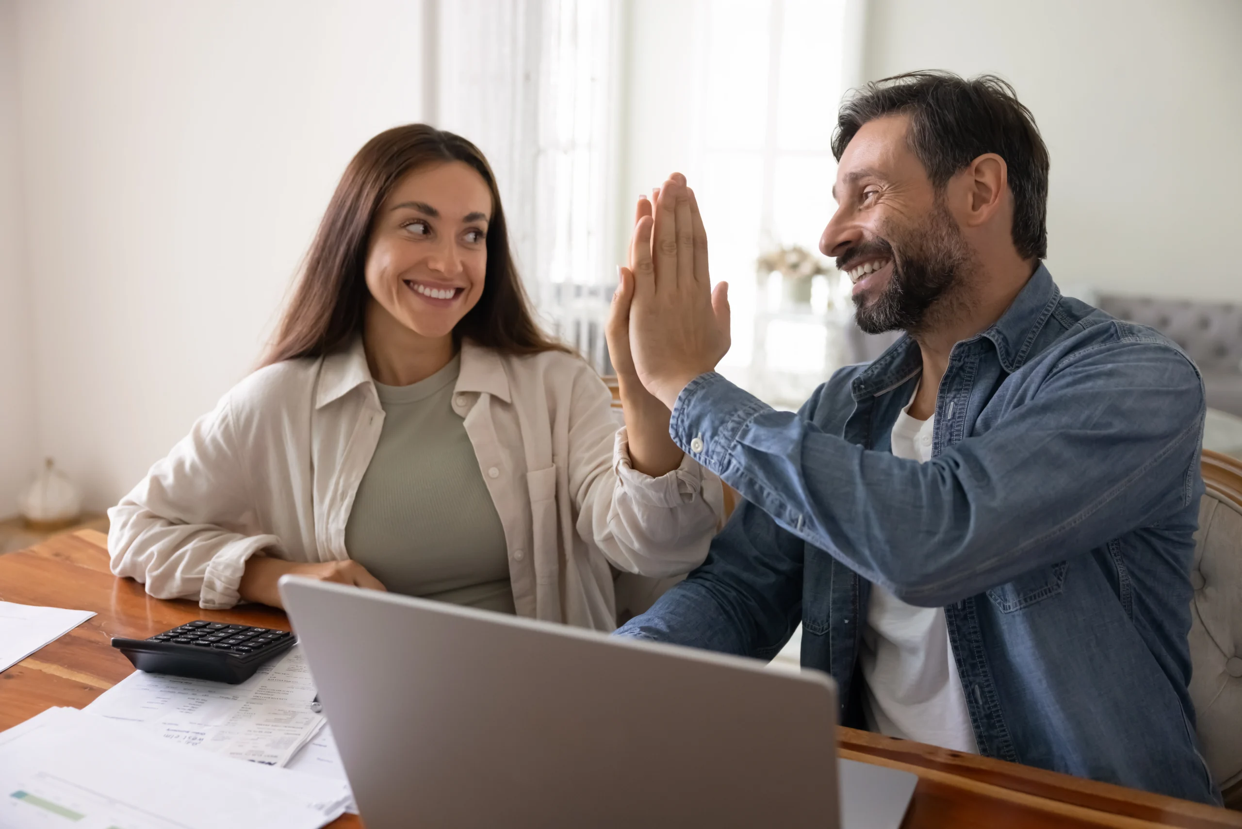 A woman high fives a man after guaranteeing his loan