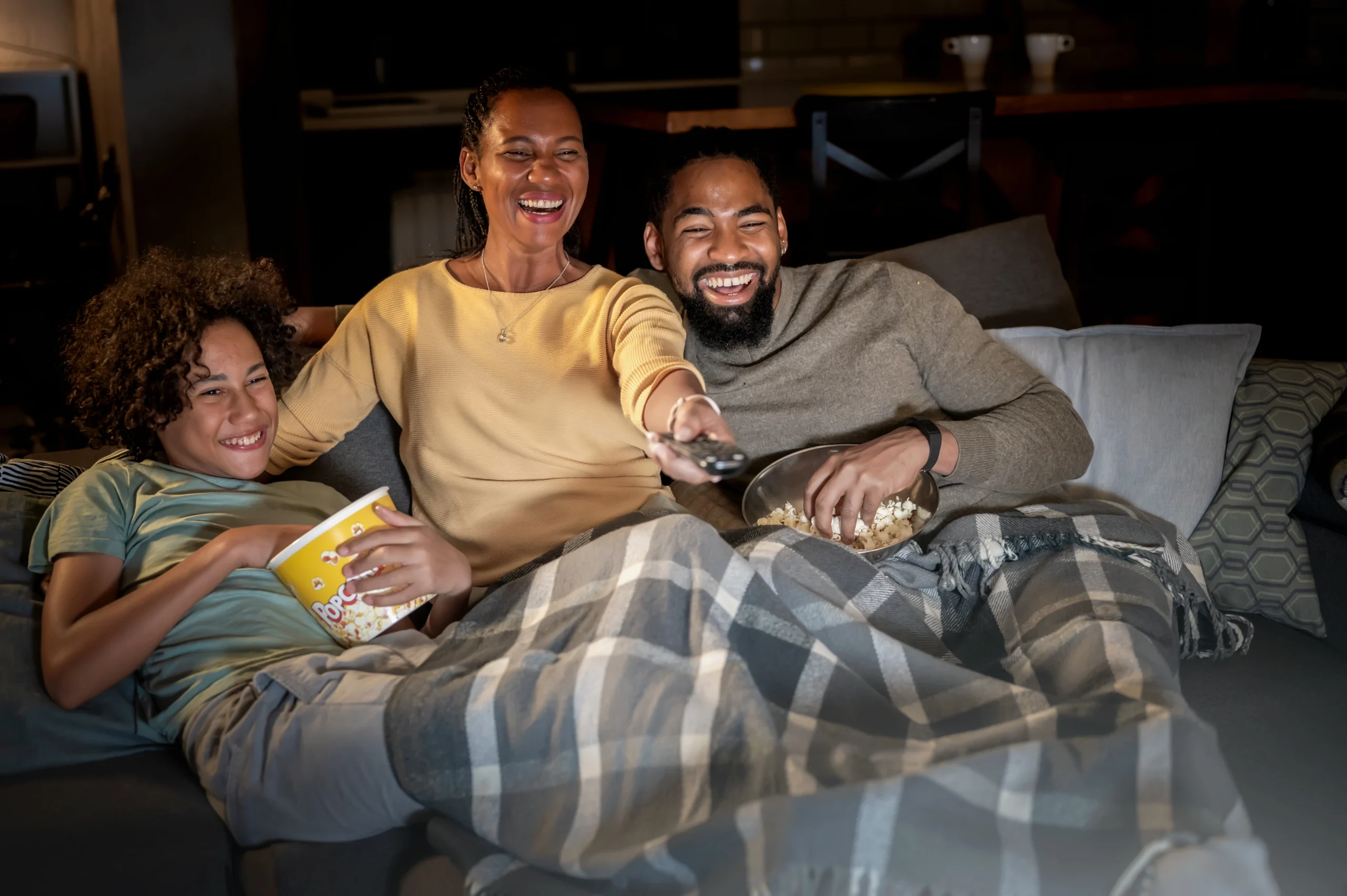 A family cuddle up on the couch for family movie night