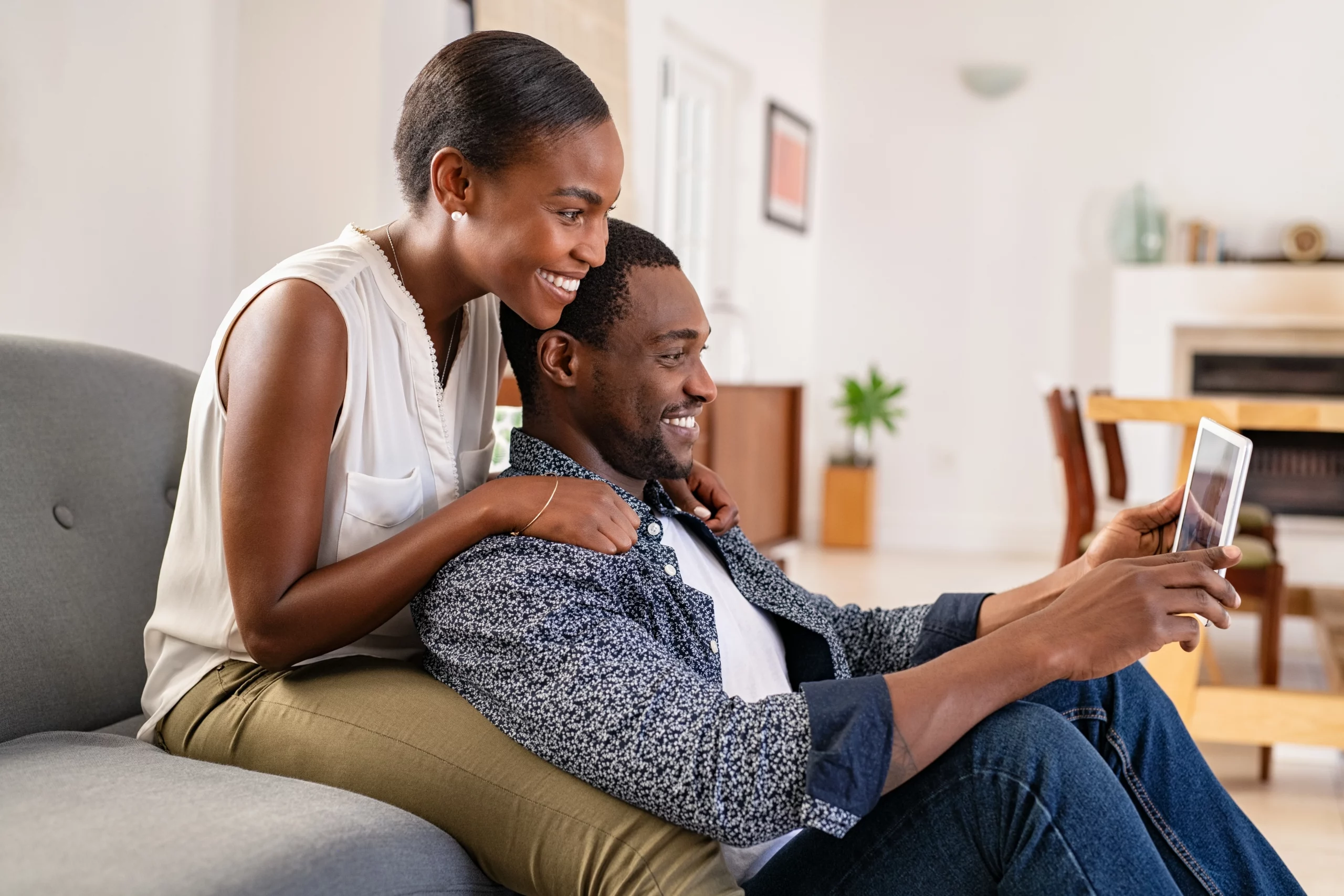 couple watching a tv show on their iPad on a couch