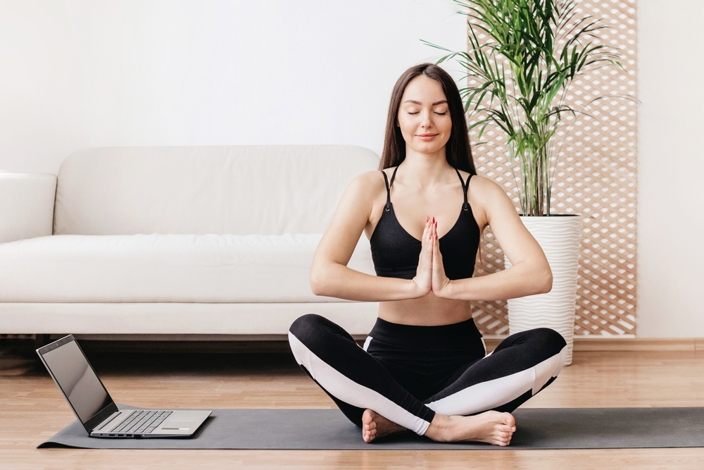 Woman doing yoga in her living room