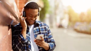 how do payday loans work; young man holding phone and listening to music