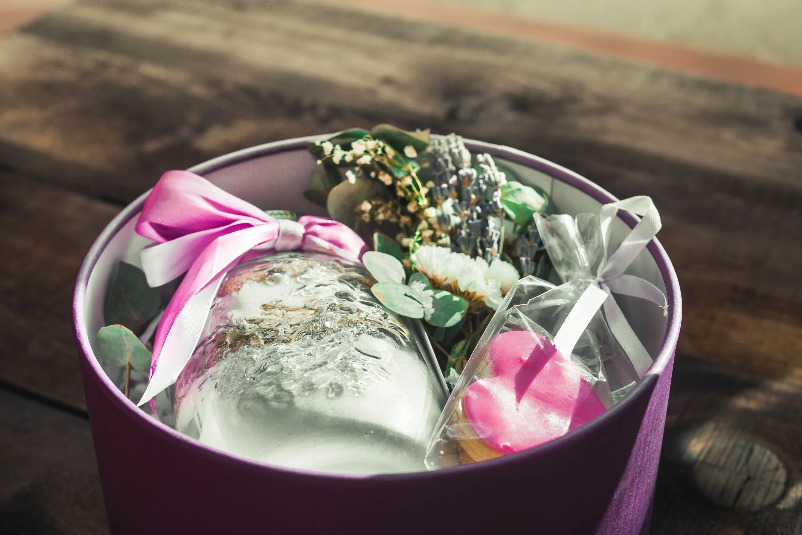 a care package of bath scents and a heart-shaped cookie in a round tin with ribbons for a last minute Mother's Day gift