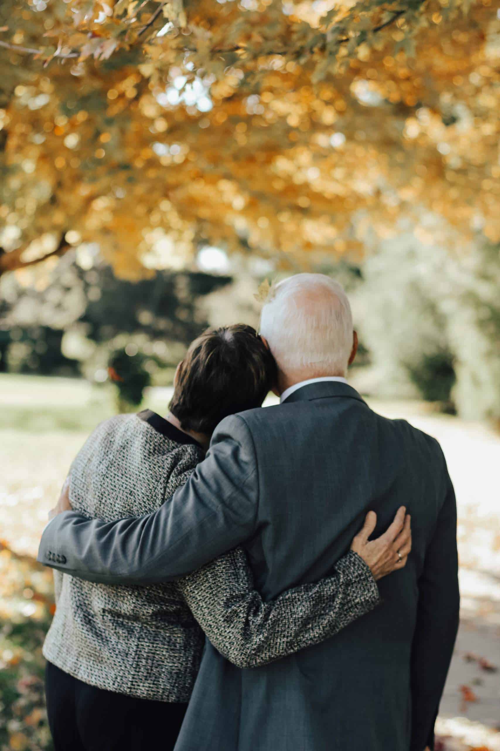 elderly couple leaning on each other