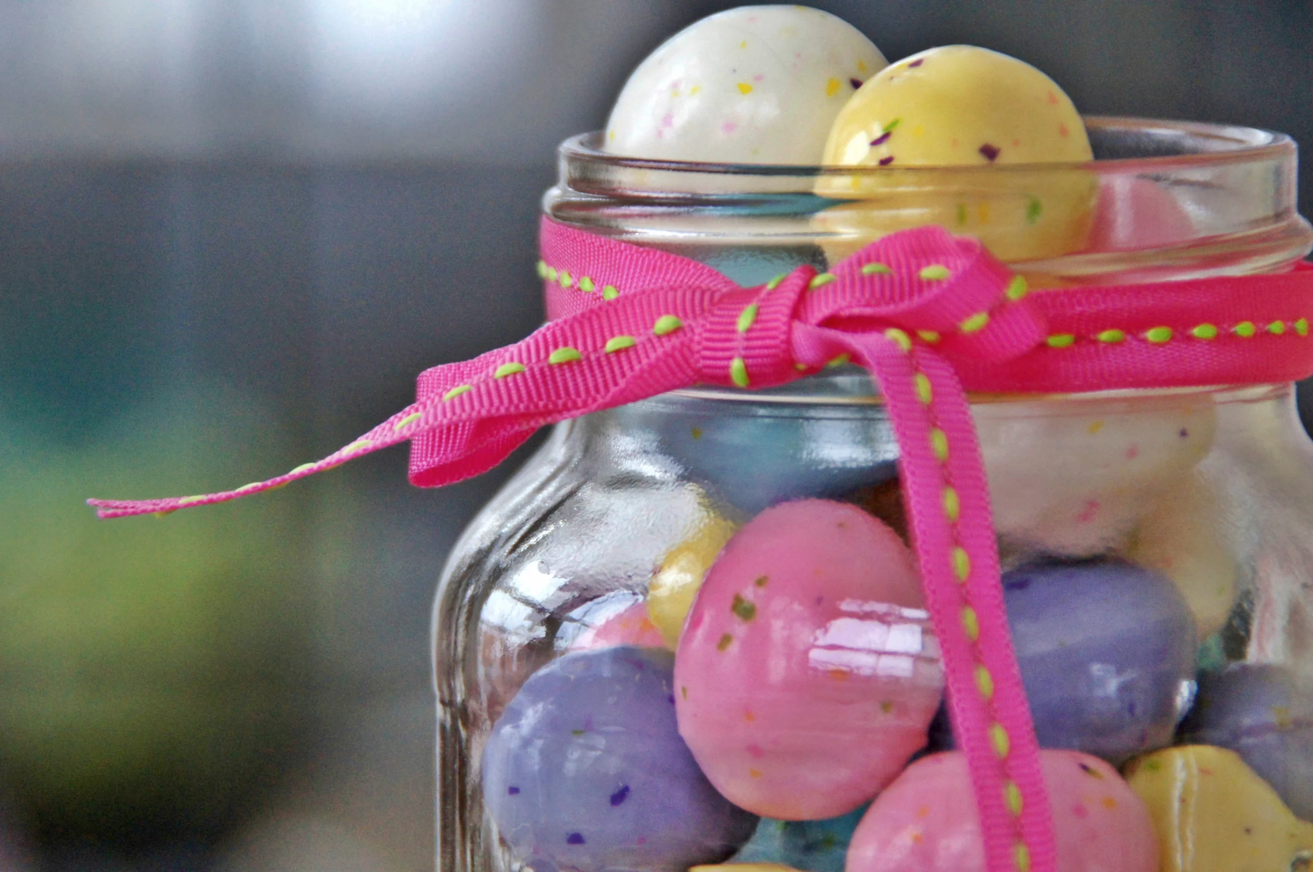 mason jar filled with Easter eggs and wrapped in ribbon
