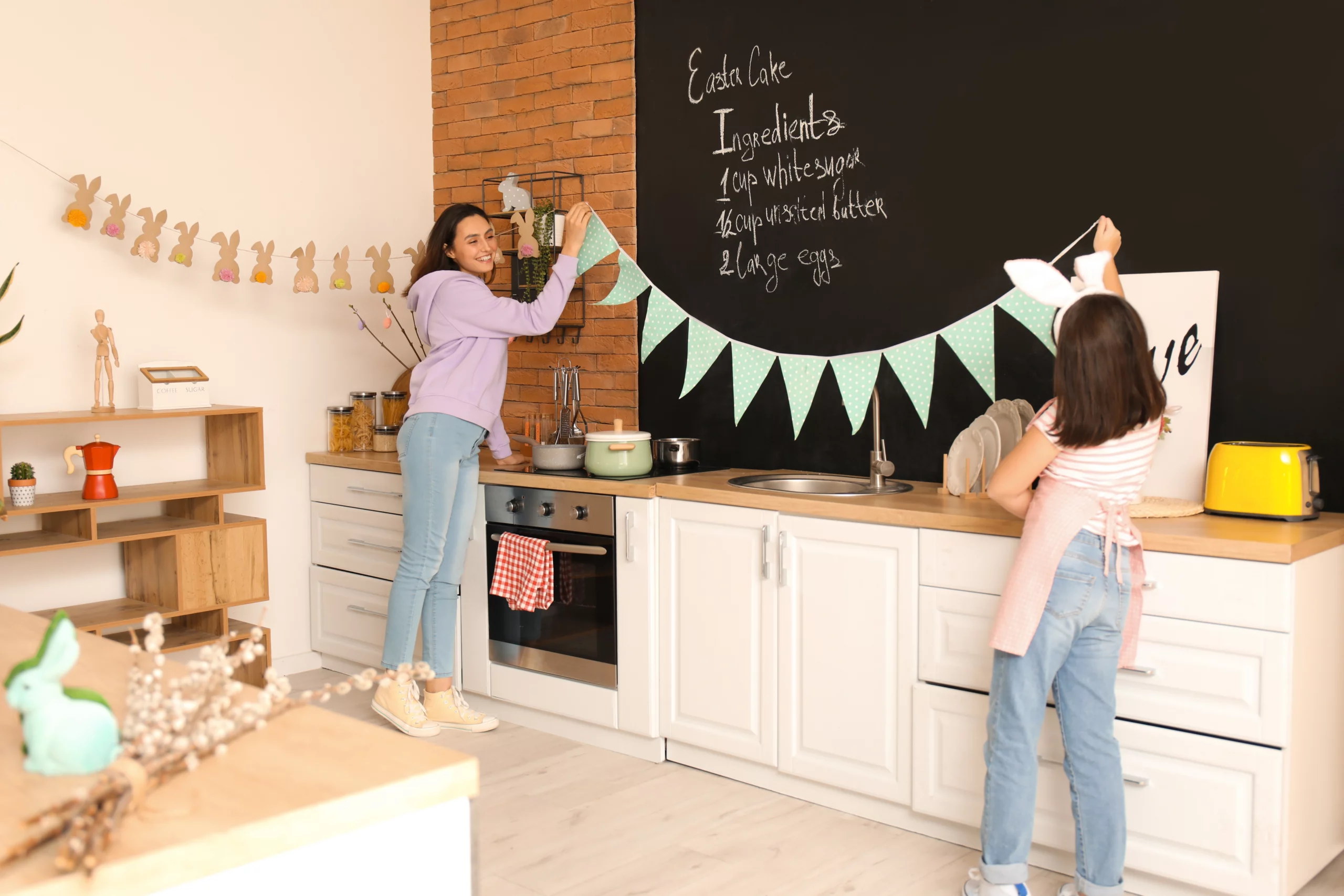 woman and child put up Easter paper garlands in their kitchen
