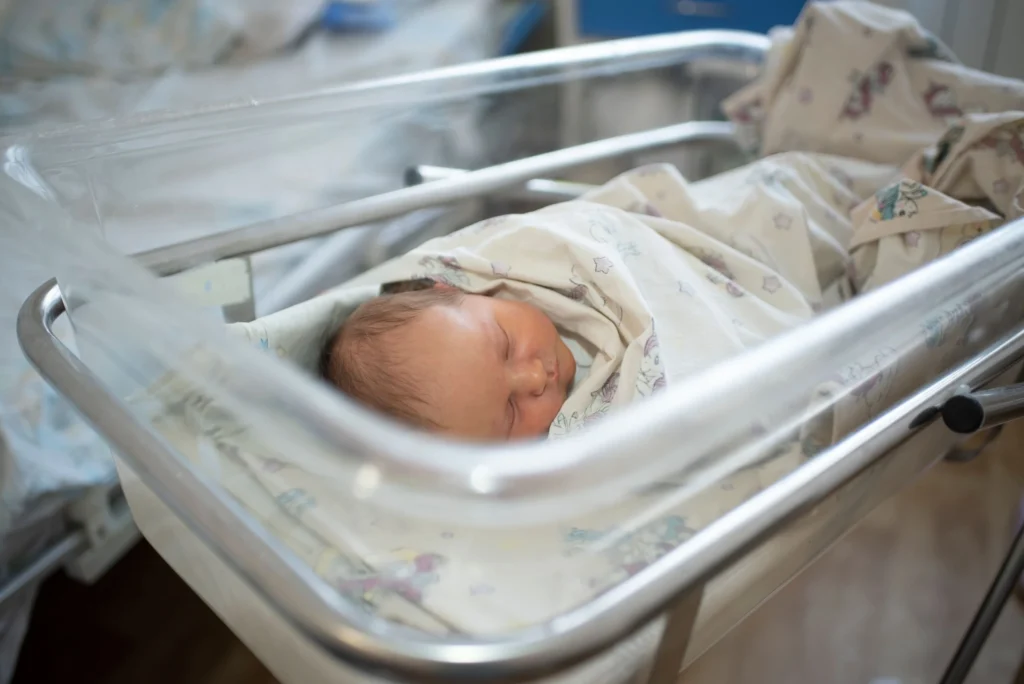 Newbown baby sleeping swaddled in blankets in the hospital post birth