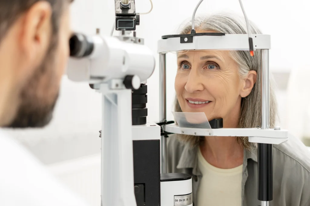 Older woman with her head in resting on an eye testing machine at the optometrist