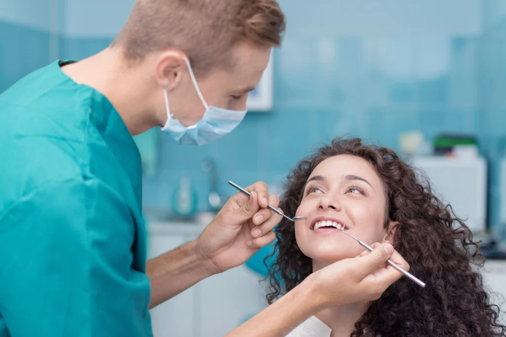 Woman smiling at the dentist as she gets a dental check-up paid for with private health insurance