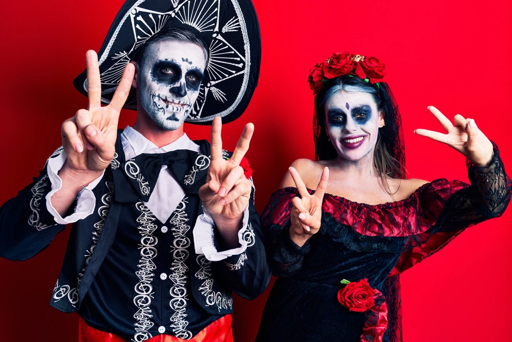 A man and a women dressed up in a couples costume of a couple celebrating day of the dead.