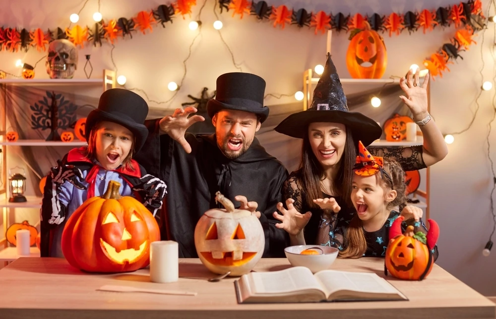 Family dressed up in black to look like witches and vampires for halloween