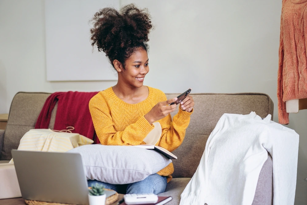 A girl snapping photos of a white turtleneck and posting it on marketplace for sale